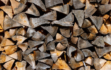 Detail of the pile of darkened wood cut for the fire. Natural dark wooden background.