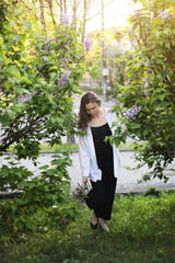 unreal stunning beautiful young woman walking in a green flowered in spring in a lavender garden...