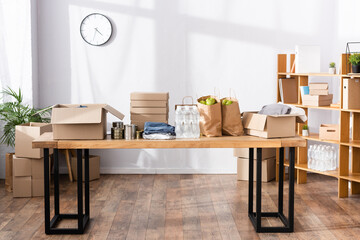Tin cans, clothes and carton boxes on table in charity center