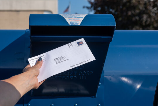 Palatine, IL/USA - 08-27-2020:  A woman is safely mailing in her application for ballot for 2020 election at the Post Office
