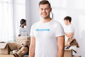 Selective focus of young volunteer looking at camera in charity center