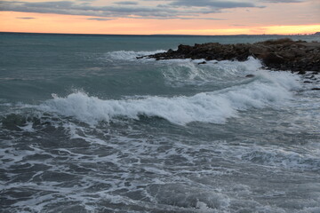 Atardecer con olas del mar mediterráneo con horizonte