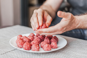 Man hands preparing meatballs with raw mincemeat