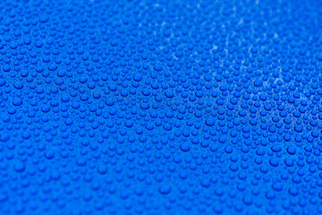 Close-up of drops of rainwater on blue metal background after nanoceramics polishing technology