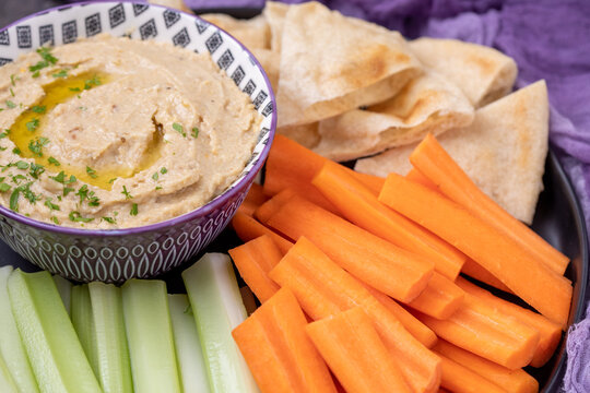Eggplant Hummus on a Platter of Celery, Carrots, and Pita Bread on a Black Table