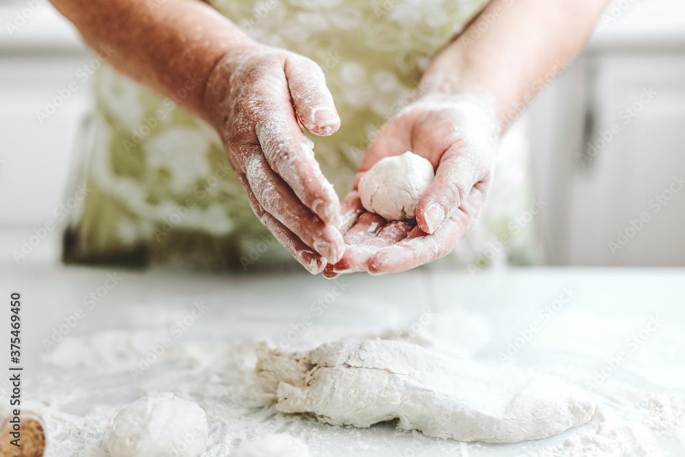 Wall mural woman kneading dough at home kitchen