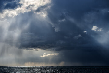 Autumn storm over the Black sea with rain and sun rays