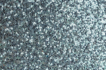 Silver sparkles close up. Bright festive background for sites and layouts.