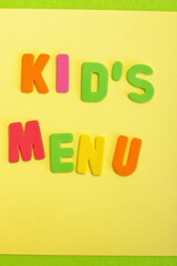 Kid's menu lettering, multicolored letters on color background, yellow green orange colors