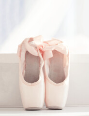 pink pointe shoes stand on a light background close-up