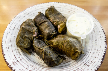 dolma - stuffed grape leaves with meat and rice on a clay plate