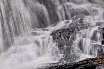 Fototapeta na wymiar Closeup of white curtains of water plunging down scenic Garwin Falls in Wilton, New Hampshire.
