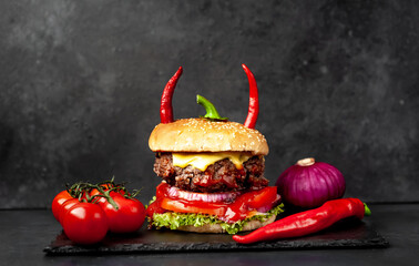 halloween pumpkin-shaped burger with red pepper horns on stone background