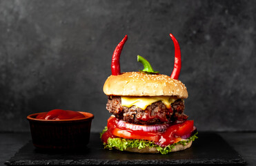 halloween pumpkin-shaped burger with red pepper horns on stone background