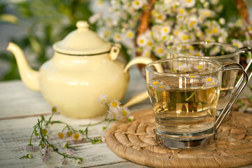 Obraz na płótnie Canvas teapot and chamomile tea cups