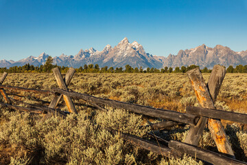 Split rail fence frames the view of the Teton mountains during Fall in Grand Teton National Park