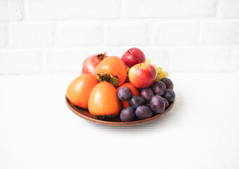 Autumn composition with fresh fruits. Apple, plum, melon, persimmon, pomegranate, grapes. Selective focus.