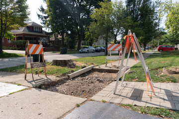 Fototapeta na wymiar Suburban Neighborhood Sidewalk under Construction Barriers
