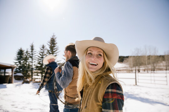 Happy female rancher walking on sunny snowy ranch