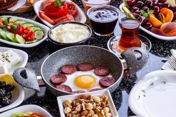 Traditional Turkish Breakfast with sausage egg pan on marble table.Close up taken             