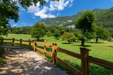 Fototapeta na wymiar Summer panorama in the mountains and wooden fence near the lake of tenno, wine route, near Lake Garda, Riva del Garda, Trentino Alto Adige, Trento, Italy