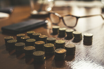 Coins, glasses and cellular phone on a wooden table, poverty living in Russia concept