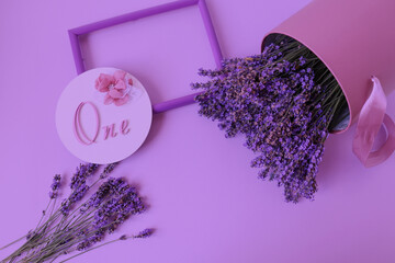 A festive arrangement of congratulations to happy birthday - frame, the inscription and the bouquets of lavender on a pastel background, top view