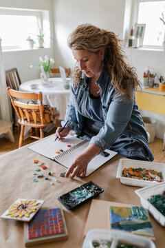 Female Artist Sketching Ideas For Mosaic In Home Art Studio