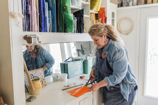 Female Artist Cutting Glass Sheet For Mosaics In Home Art Studio