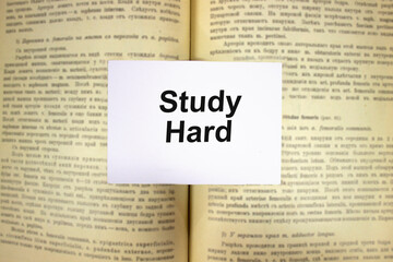 Obraz premium Study hard written in white note on open book