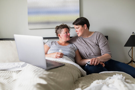 Affectionate lesbian woman caring for sick wife in bed
