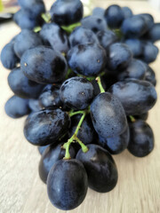 Dark ripe grapes on a wooden table