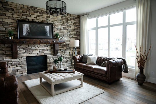 Living room with leather sofas, exposed brickwall and wooden flooring