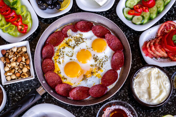 Traditional Turkish Breakfast with sausage egg pan on granite marble table.Close and large view.               