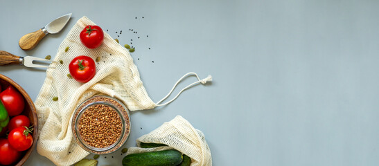 Healthy food vegetables on grey background. Groceries in recycle textile bags. Eco friendly plastic free low waste lifestyle. Zero waste bio food storage and shopping concept Banner copy space