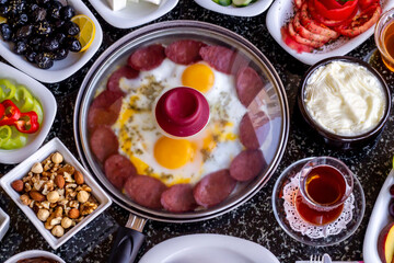 Traditional Turkish Breakfast with sausage egg pan on granite marble table.Close and large view.               