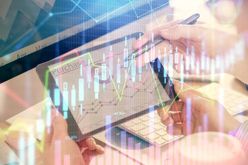 Double exposure of man's hands holding and using a phone and financial chart drawing. Market analysis concept.