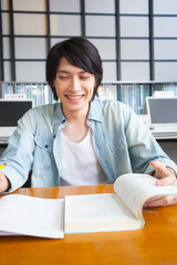 図書室で勉強する男子大学生