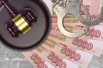 5000 russian rubles bills and judge hammer with police handcuffs on court desk. Concept of judicial...