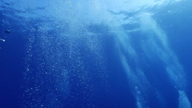 air bubbles slow  underwater coming up scenery dark blue and sun shine ocean scenery from scuba divers