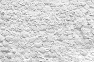 White beautiful natural texture stone coated with clay paint. The wall of the historic old ancient building. Place for text on the handmade city facade. The art of stucco in interior of house.