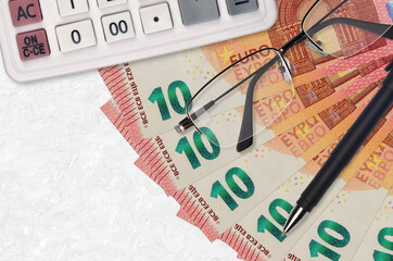 10 euro bills fan and calculator with glasses and pen. Business loan or tax payment season concept