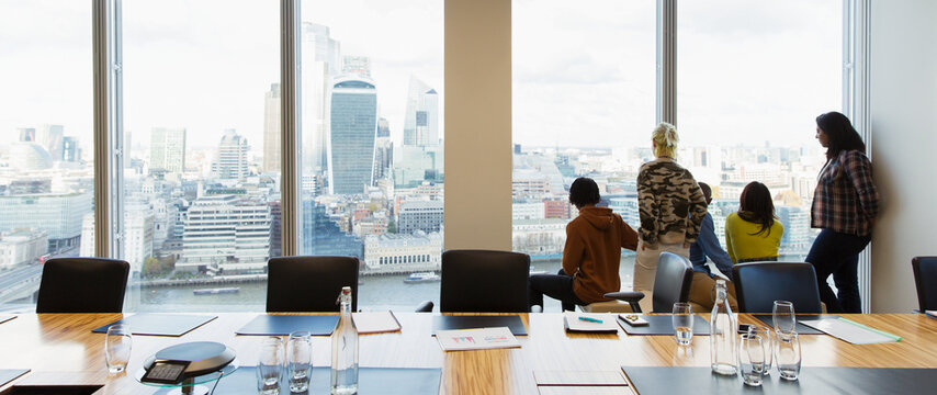 Business people looking out highrise office window, London, UK