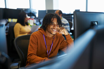 Smiling businessman working at computer in office