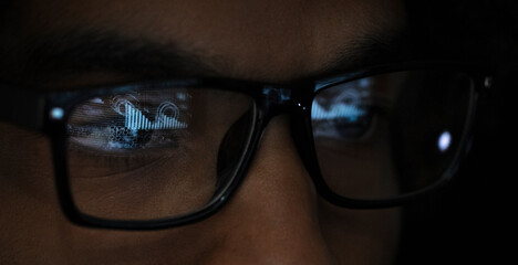 Close up reflection of laptop in eyeglasses of businesswoman
