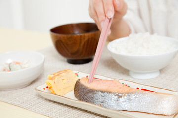 焼き鮭を食べる女性の手元