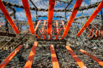 Crab traps orange gateway, dirty cages used to catch large numbers of crabs in Mudeford Quay UK, sea creatures exploitaition, crabs once entered have no way out, closeup of lobster pots inside 