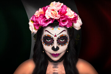 Retrato al aire libre de muchacha formada como una catrina con flores en el pelo.