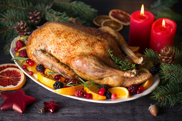 Whole roasted duck with oranges, berries and herbs. Christmas dinner meal table. Horizontal photo