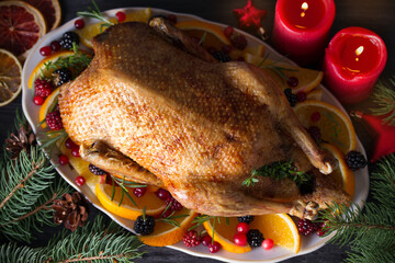 Whole roasted duck with oranges, berries and herbs. Christmas dinner meal table. Overhead, flat lay